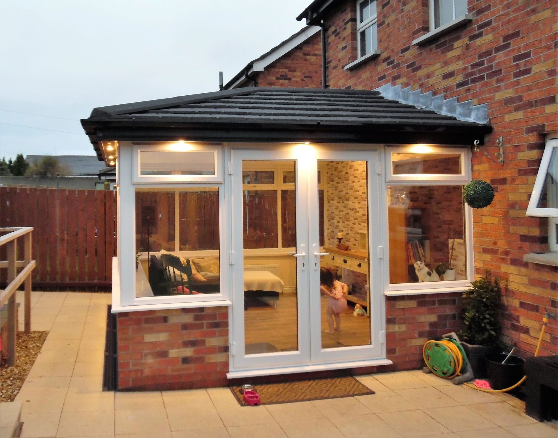 A brick house with a patio and a conservatory