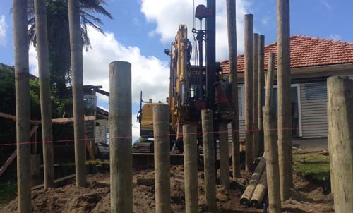 Worker monitoring drilling holes in ground