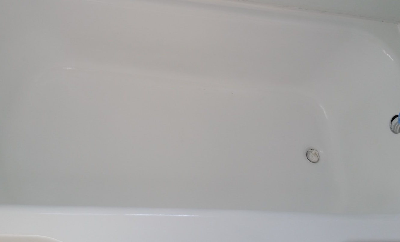 A white bathtub with a drain on the side of it.