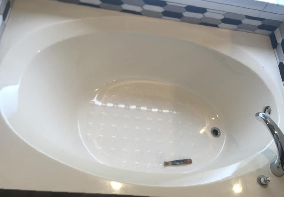 A white bathtub in a bathroom with a faucet.