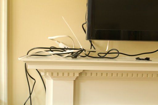 A television is sitting on top of a fireplace mantle.