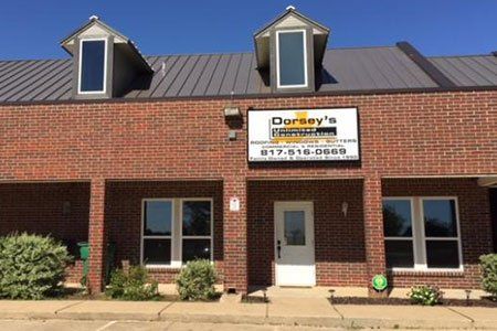 Storefront — Kennedale, TX — Dorsey's Unlimited Construction Dorsey's Insurance building with brick facade, two dormers, sign, and front door.