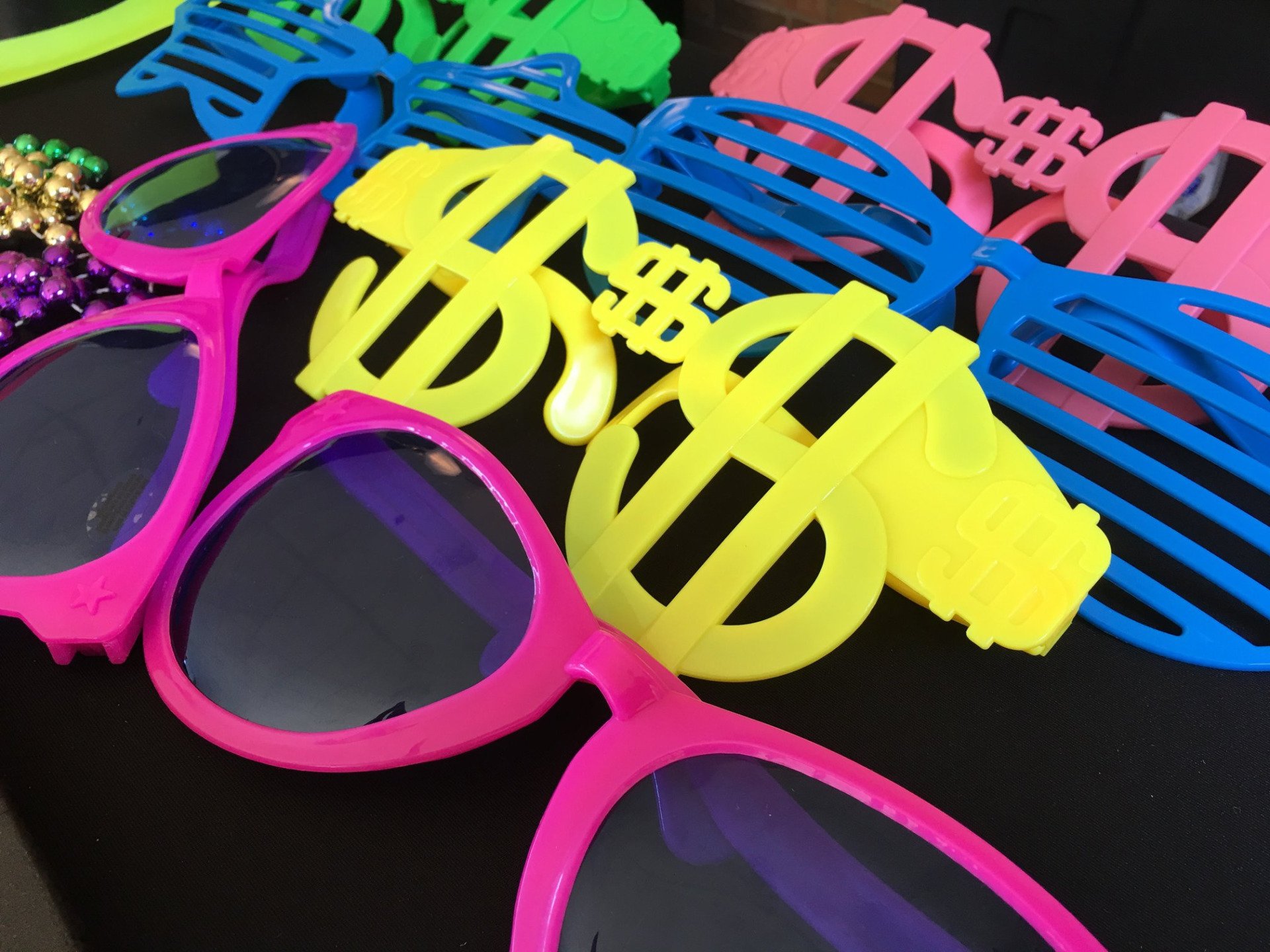 A bunch of colorful sunglasses with dollar signs on them
