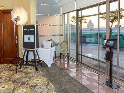 A photo booth is set up in a room with lots of windows.