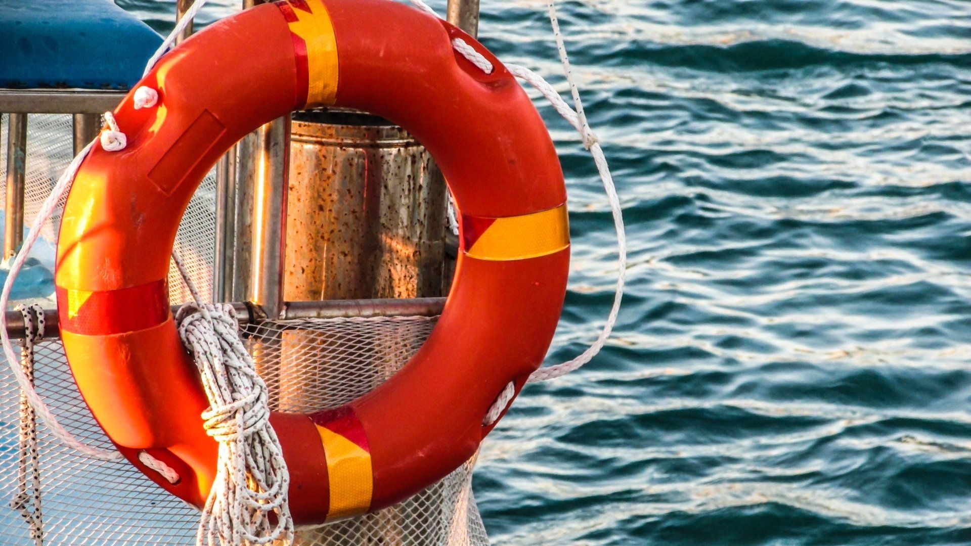 a life preserver is hanging from a pole in the water .