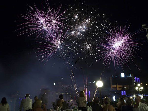 dei fuochi artificiali viola e bianchi e delle persone