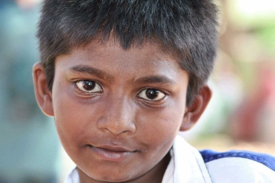 A close up of a young boy 's face looking at the camera.