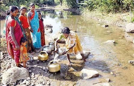 A group of people are standing next to a river.