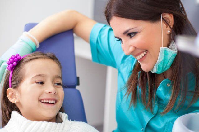 dentist and girl female dentist reassuring young girl