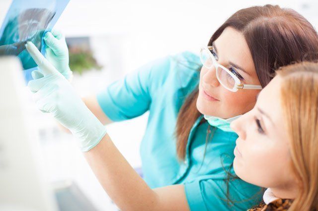 dentist looking at xrays dentist and patient looking at xray results