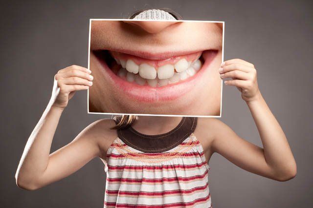 girl comic smile girl holding enlarged comic smile picture in front of face