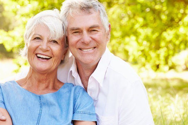 happy mature couple mature couple sitting in shade on grass