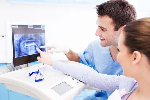 looking at scan on montior dentist looking at scan of teeth on monitor with patient