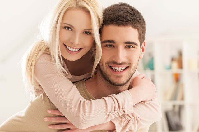 piggy back couple young couple smiling to camera