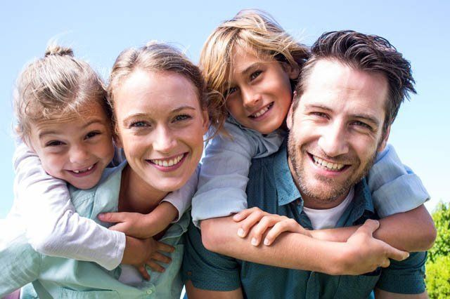 young couple piggy backing kids