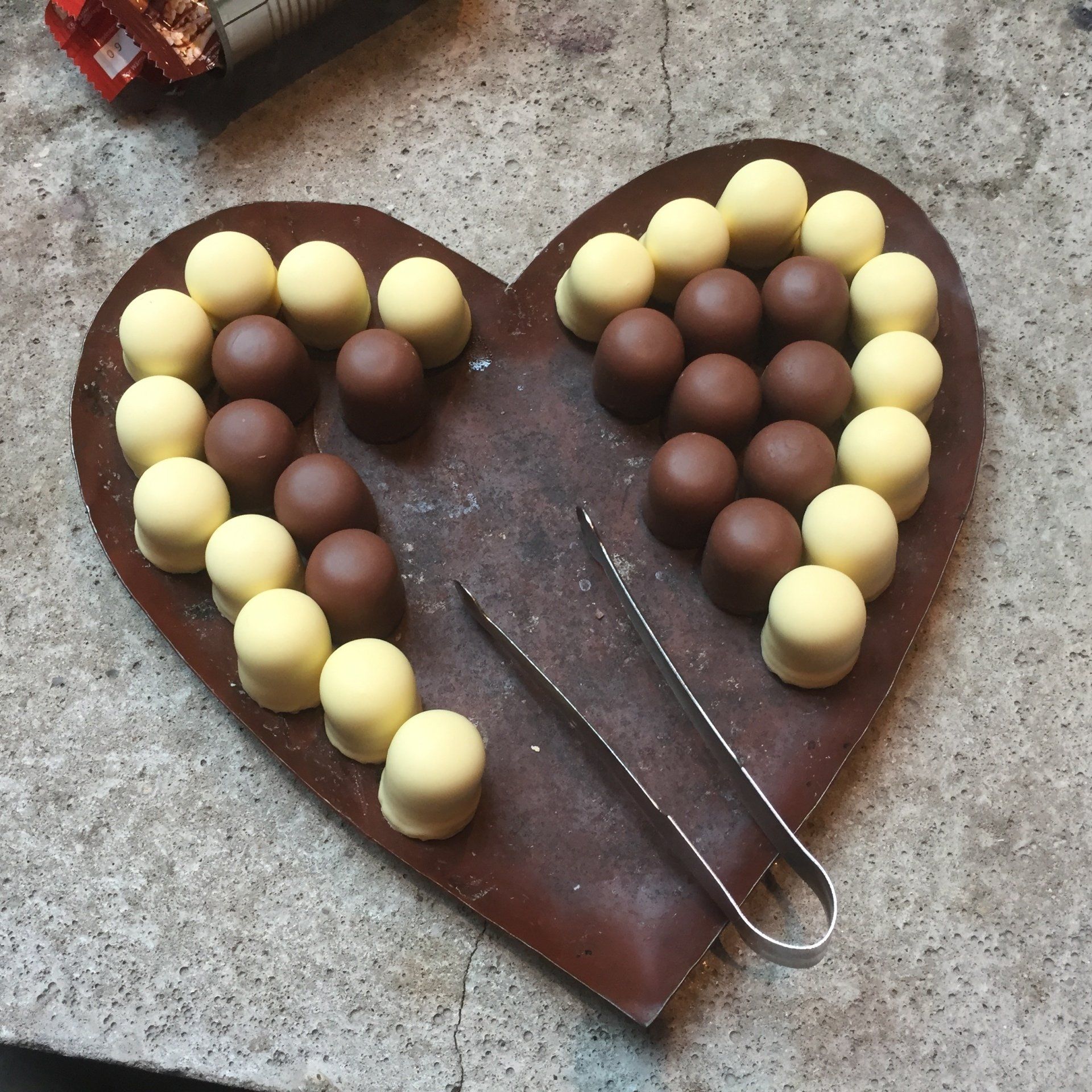 Ein herzförmiges Tablett mit Schokoladenkugeln darauf