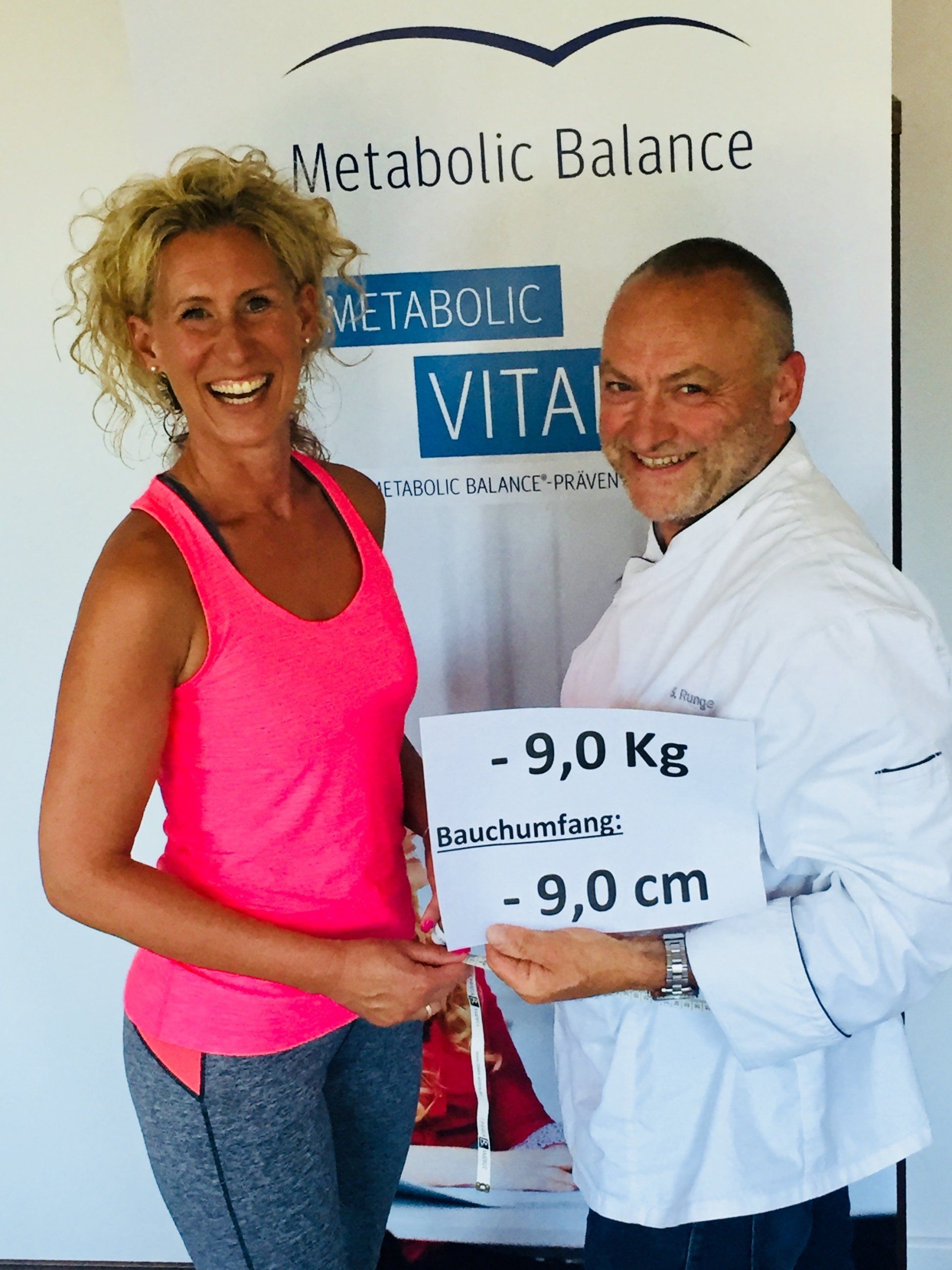 Ein Mann und eine Frau halten ein Schild mit der Aufschrift „Metabolic Balance“