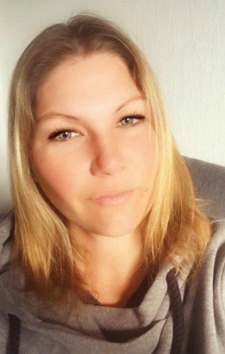 Eine Nahaufnahme des Gesichts einer Frau, die einen grauen Kapuzenpullover trägt.