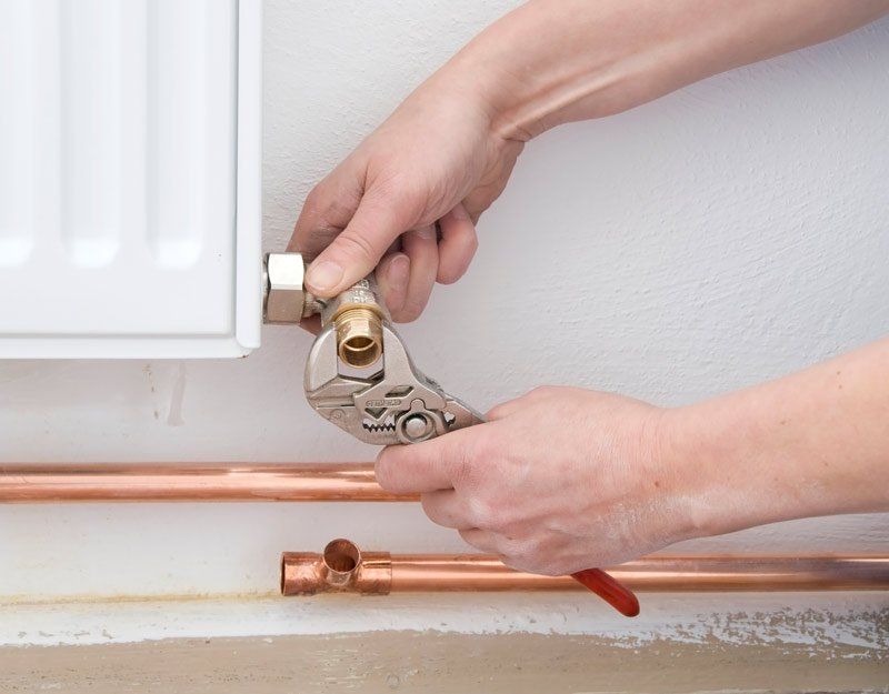 two hands of plumber doing re-piping work two hands of plumber doing re-piping work