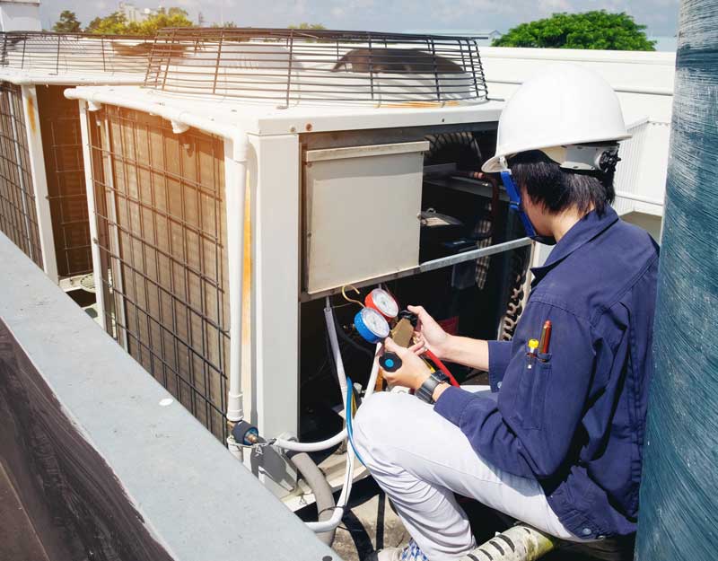 Technician is checking air conditioner Technician is checking air conditioner