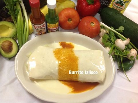 Burrito Jalisco on a white plate, drizzled with orange sauce. Ingredients include avocado, tomatoes, peppers, and hot sauces.