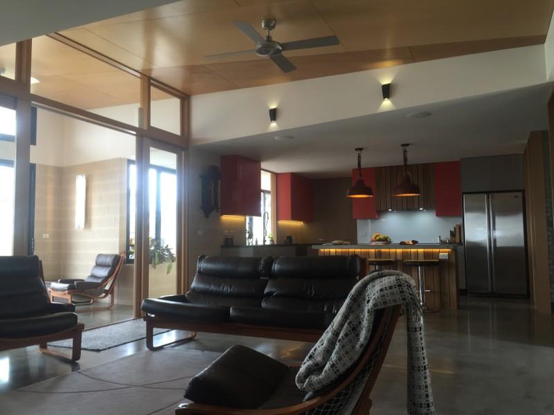 A living room with a couch and chairs and a ceiling fan