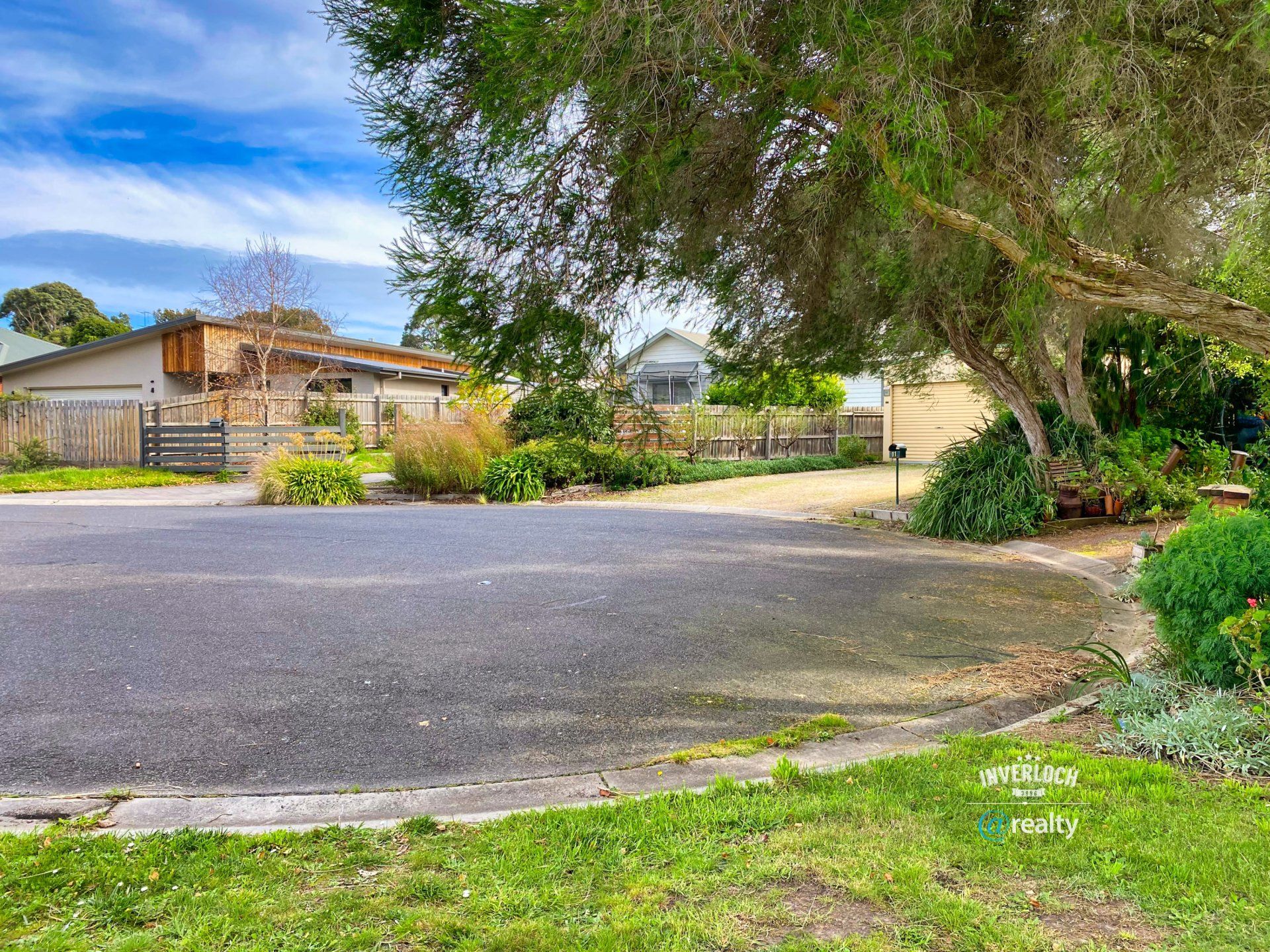 There is a house in the background and a tree in the foreground.