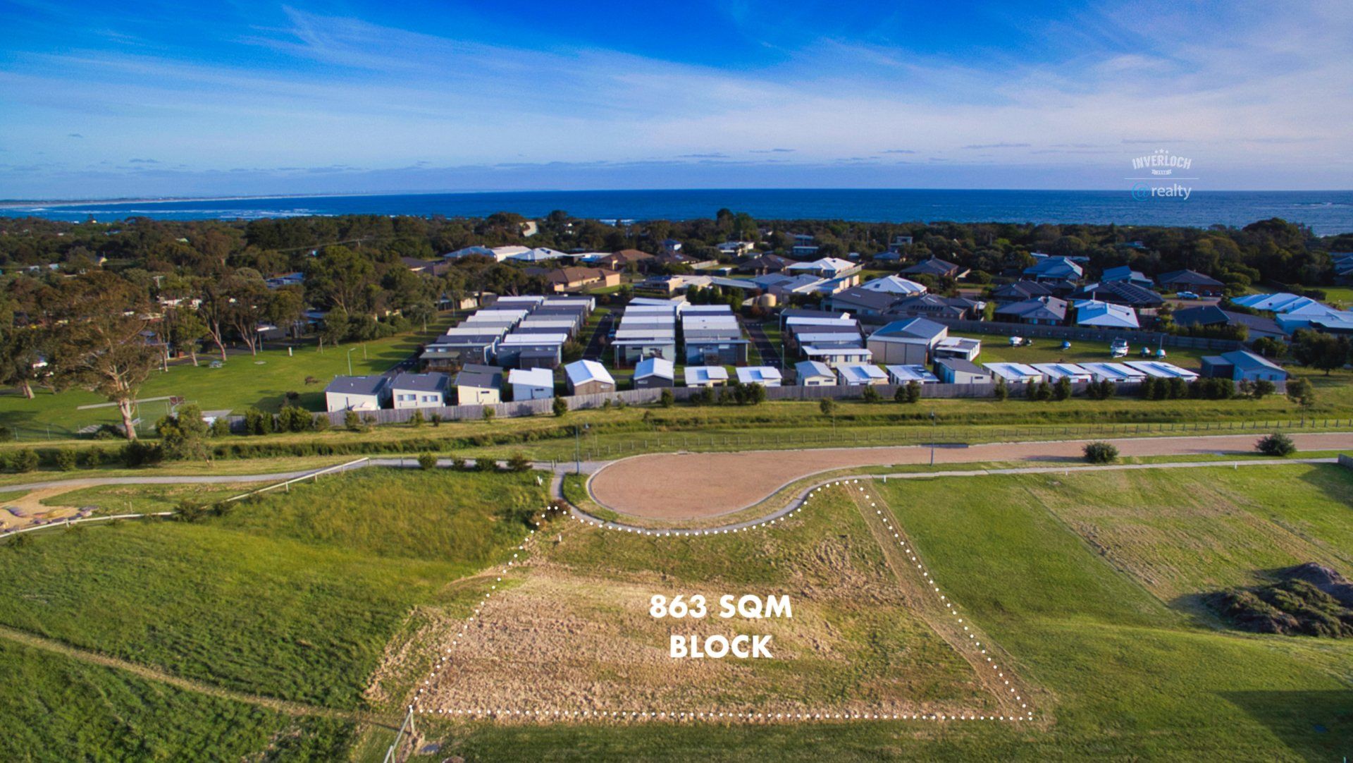 An aerial view of a residential area next to the ocean.