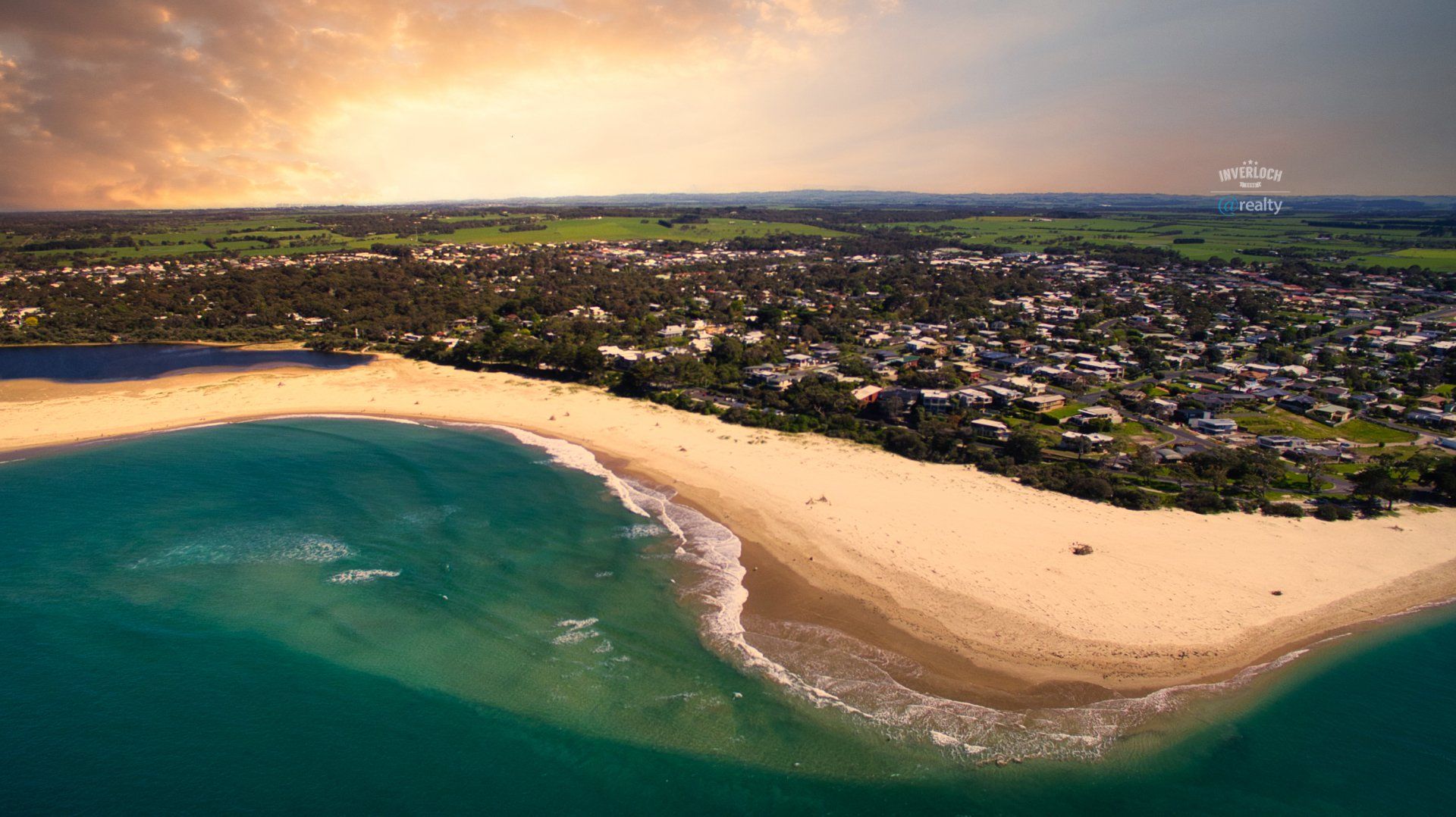 An aerial view of a beach with a city in the background.