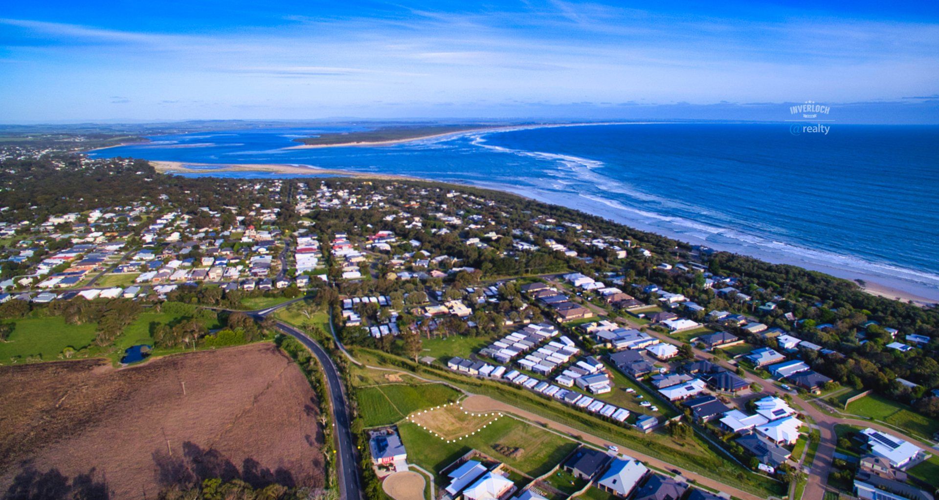 An aerial view of a residential area next to the ocean.