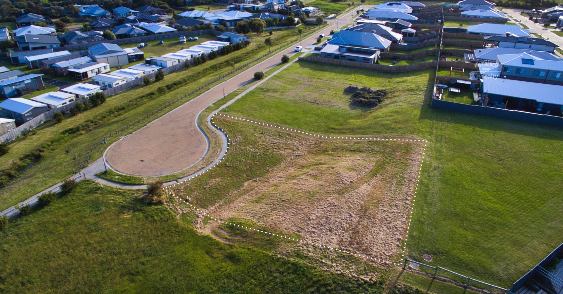 An aerial view of a residential area with a lot of grass and houses.