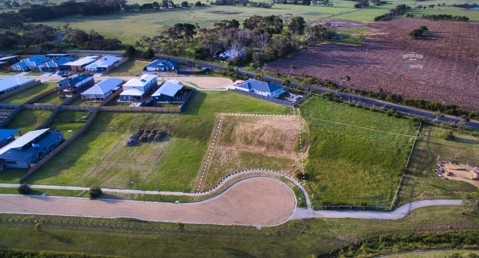 An aerial view of a residential area with lots of grass and houses.