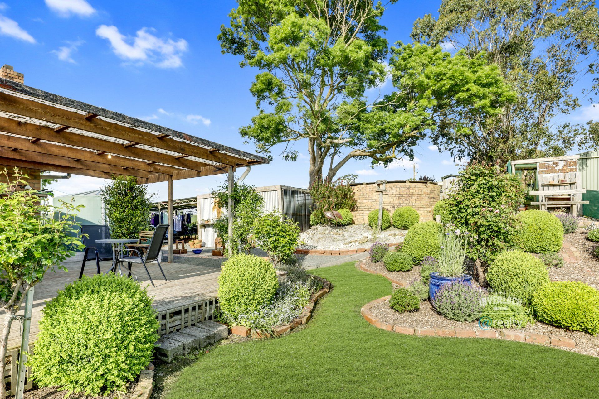 There is a patio with a table and chairs in the backyard.