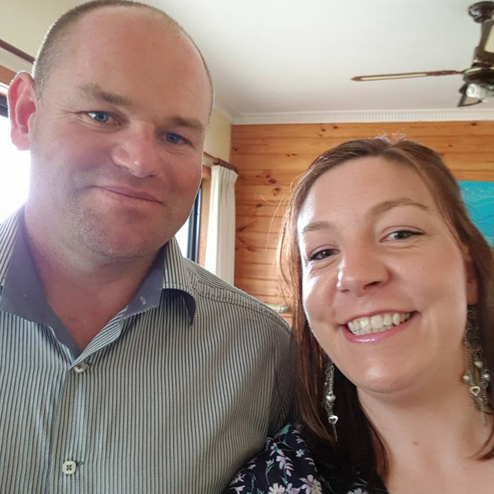 A man and a woman are posing for a picture and smiling
