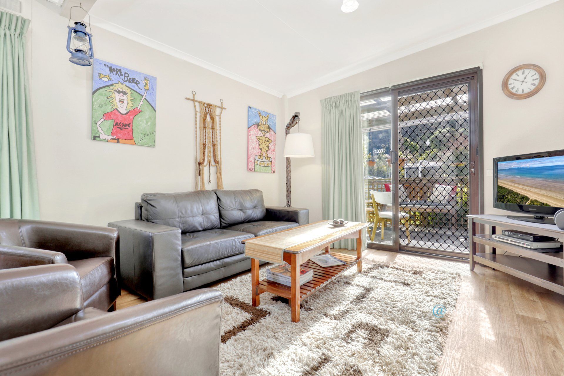 A living room with a couch , chairs , coffee table and television.