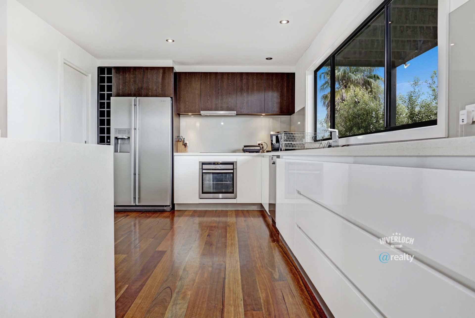 A kitchen with stainless steel appliances and wooden floors