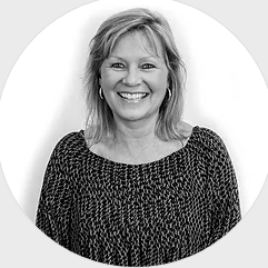 A black and white photo of a woman smiling in a circle.