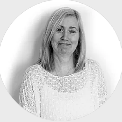 A black and white photo of a woman in a white sweater.