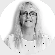 A black and white photo of a woman wearing glasses and a white shirt.