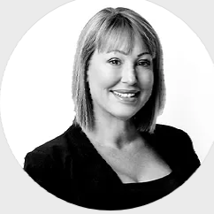 A black and white photo of a smiling woman in a circle.