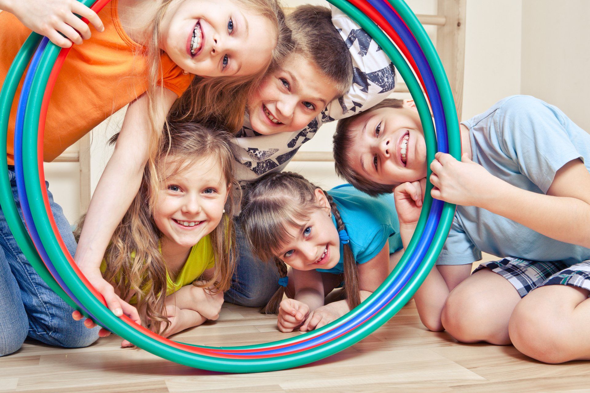 Montessori School — Five Cheerful Kids Looking Through A Hula Hoop in Glenshaw, PA Montessori School — Five Cheerful Kids Looking Through A Hula Hoop in Glenshaw, PA