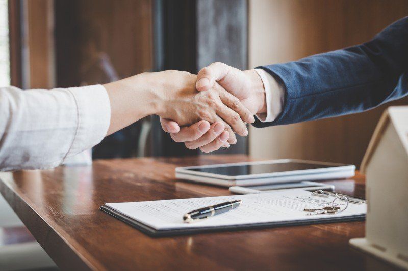 stretta di mano tra avvocato e cliente in studio