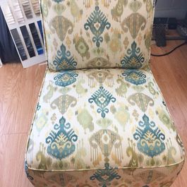 Upholstered armchair with a teal and green ikat pattern.
