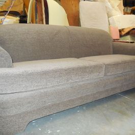 Gray upholstered sofa in a workshop setting.