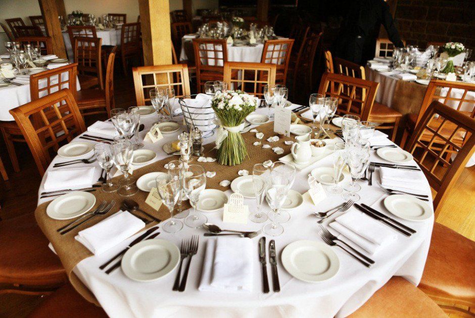 a table set for a wedding reception with plates and silverware