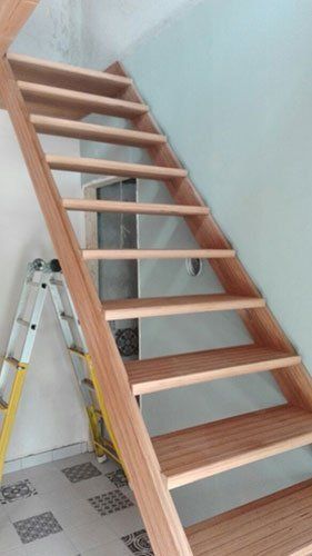 delle scale in legno e accanto una scala  in metallo