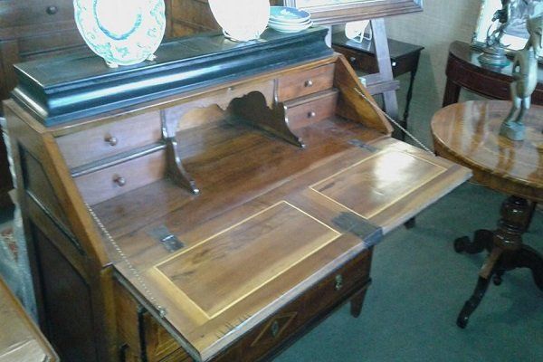 un mobile in legno con dei cassetti e una mensola con due piattini da decorazione