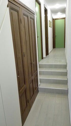un corridoio e delle porte di color verde