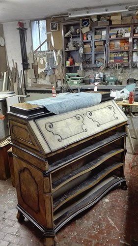 un mobile in legno con dei disegni in una falegnameria