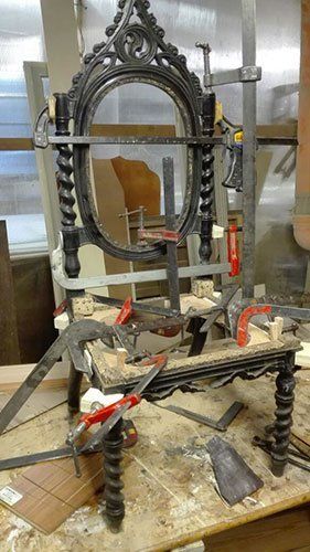 struttura di una sedia in legno con sopra degli attrezzi